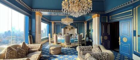A luxurious room with a city view, a chandelier, and a dining area.