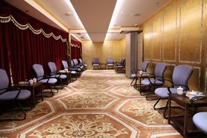 A conference room with rows of chairs, a patterned carpet, and a red curtain backdrop. - Nanjing Grand Hotel (Nanjing)