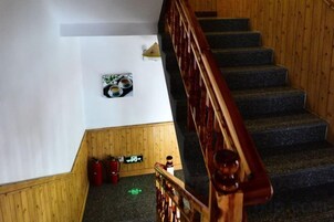 Una escalera con barandillas de madera y peldaños alfombrados.