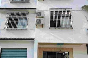 A building with barred windows and air conditioning units.