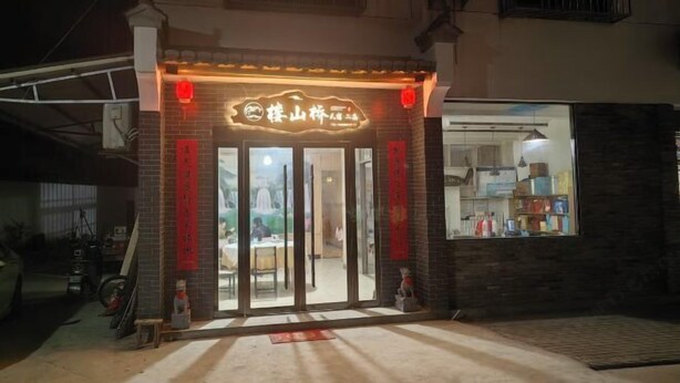 A restaurant with a traditional Chinese sign, a brick facade, and a visible interior through the glass doors. - Loushanqiao Homestay No.2 (Shitai)