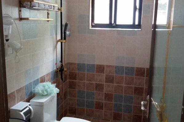 A bathroom with a toilet, a hand dryer, and a window. - Loushanqiao Homestay No.2 (Shitai)