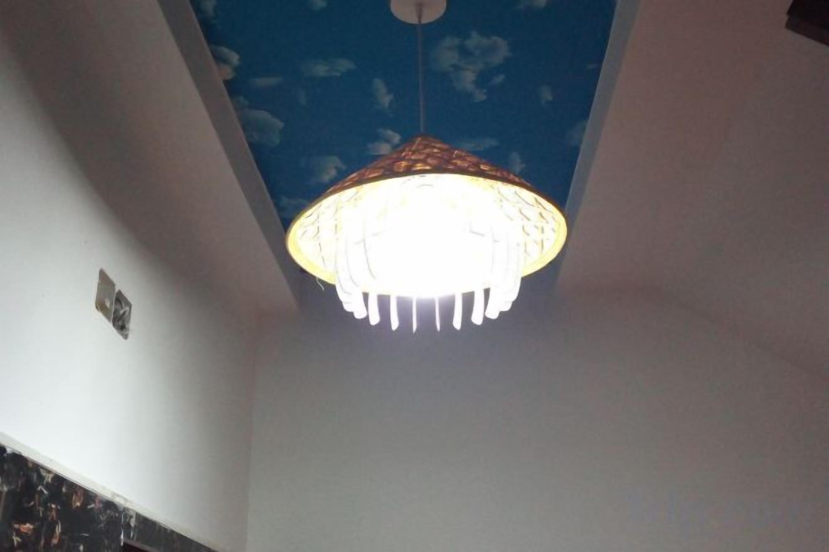 A ceiling with a hanging light fixture.