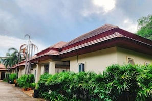 A row of single-story buildings with a uniform architectural style, featuring a flat roof and a light-colored facade. - Villa Prima Karon Beach (Phuket)