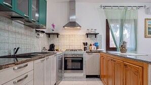 Une cuisine moderne équipée d’une cuisinière, d’un four et d’un plan de travail en granit.