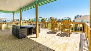 Una terrazza coperta all'aperto con barbecue, sedie e vista sulle case.