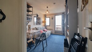 Un espacio habitable compacto con kitchenette, comedor y sofá con vistas.