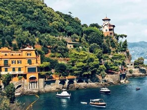 A coastal town with buildings on a hillside, a bridge, and boats on the water. - Appartamento N.9, Appartamento N.9 secondo piano (San Salvatore)