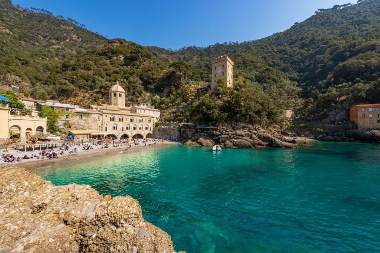 A coastal town with a prominent church, a tower, and a beach area.