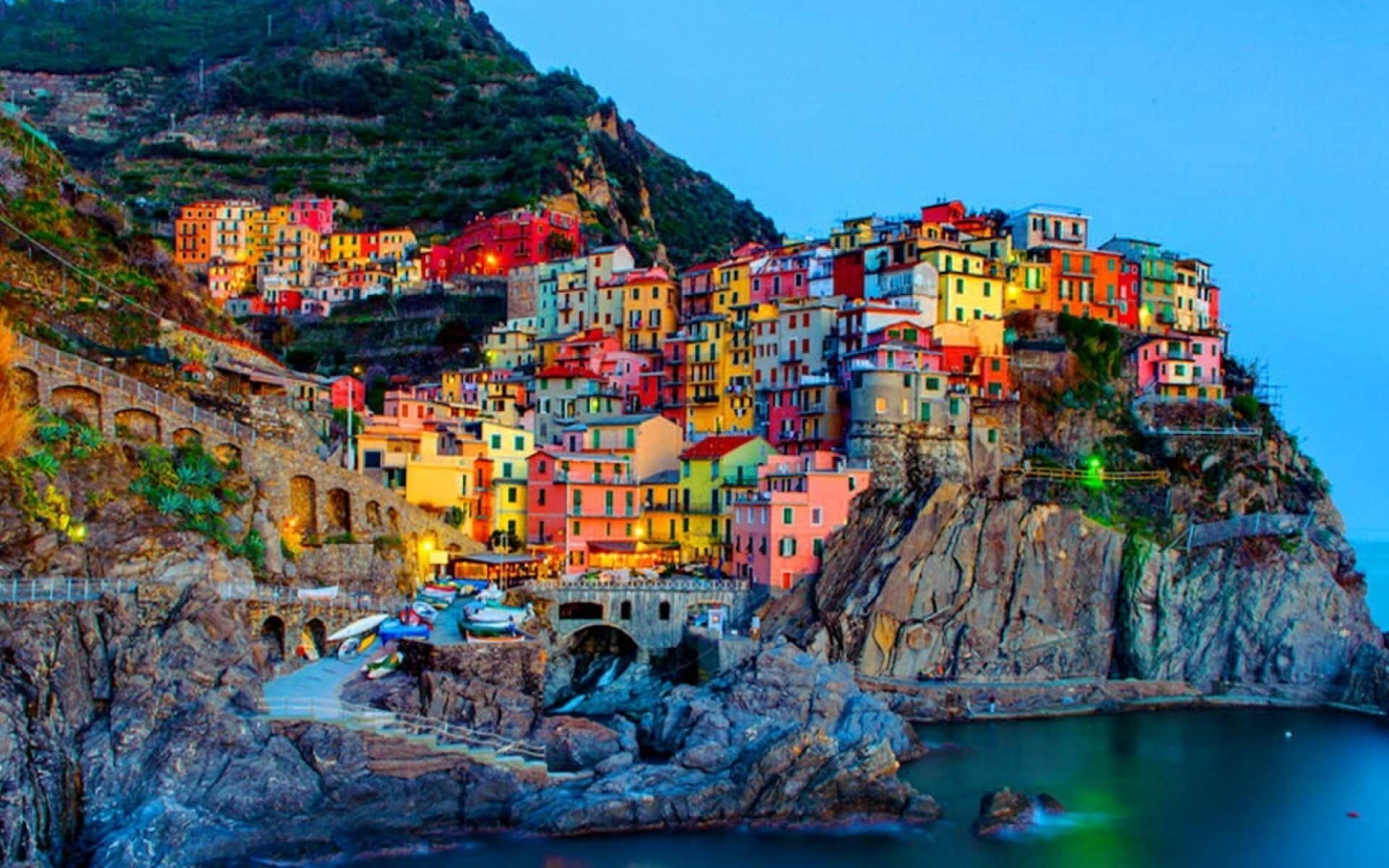 Un village côtier aux bâtiments colorés, adossé à une falaise.
