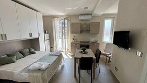 A compact room with a bed, a dining table with chairs, a kitchenette, and a TV mounted on the wall. - Apartment N.7, Appartamento N.7 Secondo piano (San Salvatore)