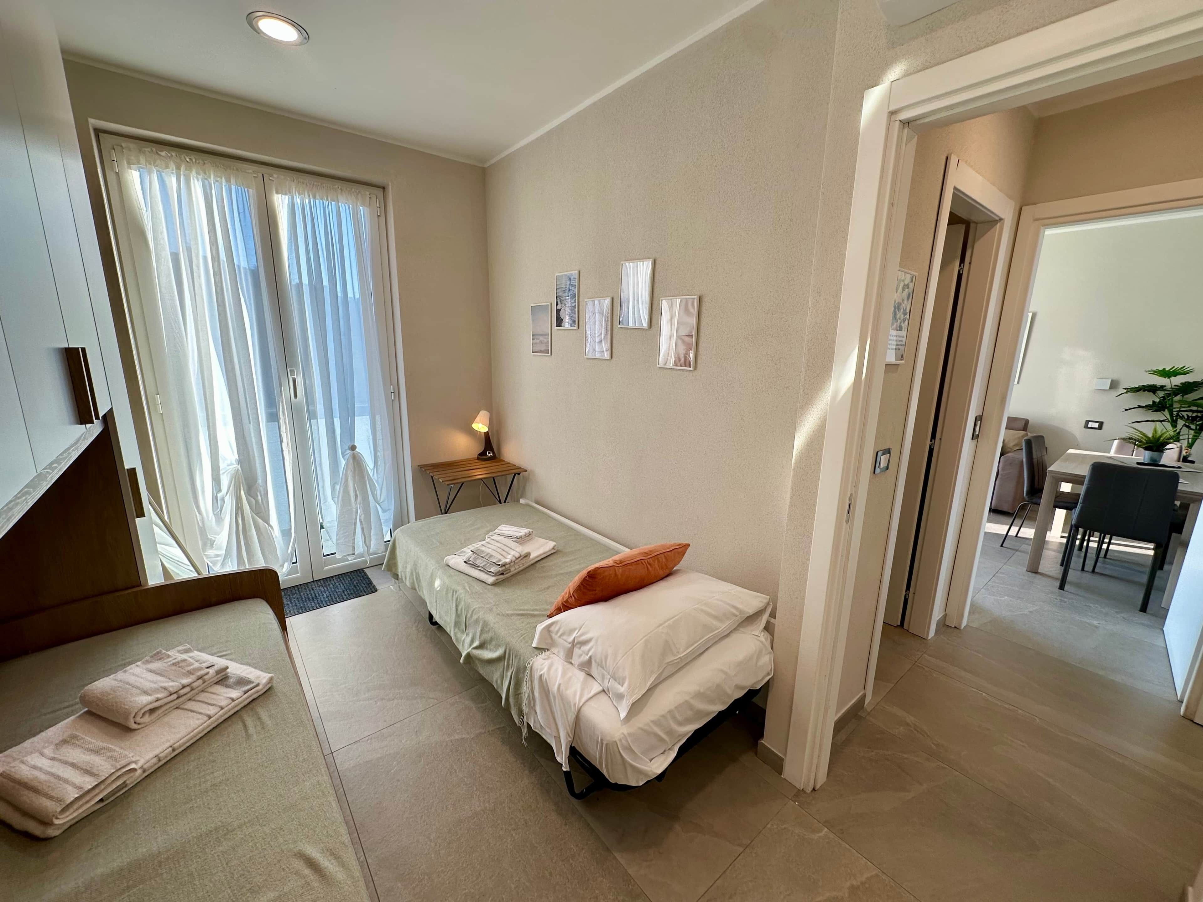 Een hotelkamer met een bed, bureau, stoel en een eethoek.