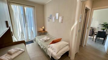 Een hotelkamer met een bed, bureau, stoel en een eethoek.