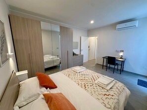 Un dormitorio con cama, escritorio y equipo de aire acondicionado.