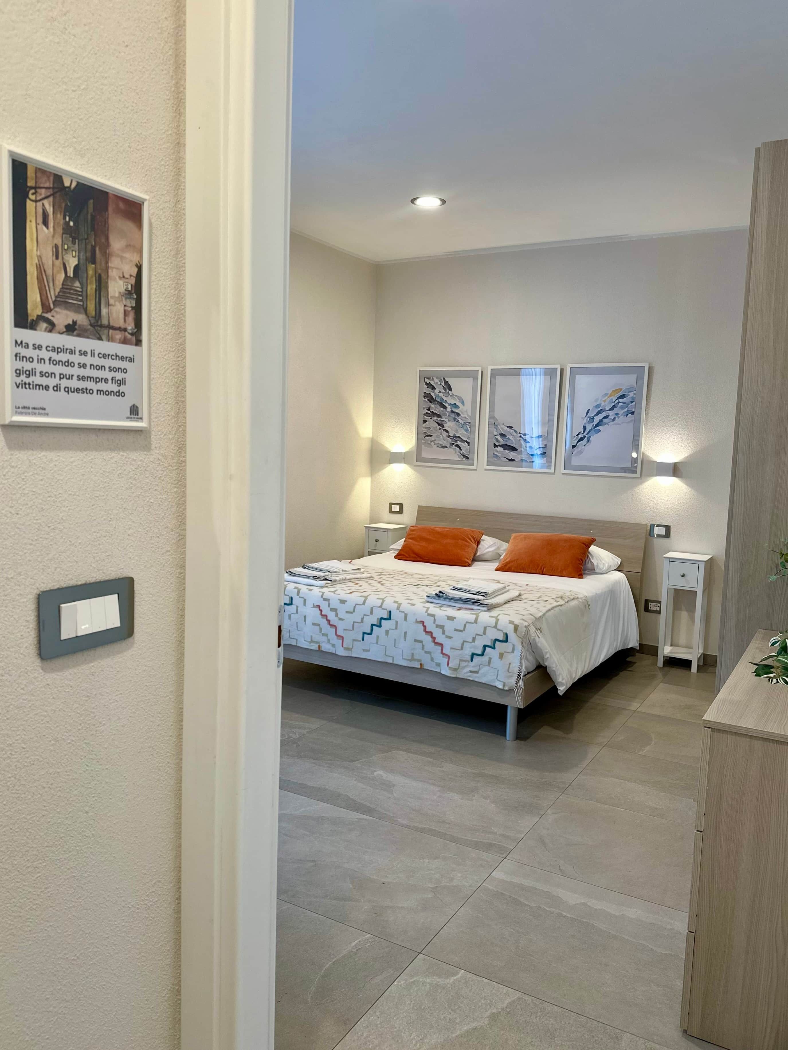Ein Schlafzimmer mit einem Bett, Nachttischen und Wandbildern.