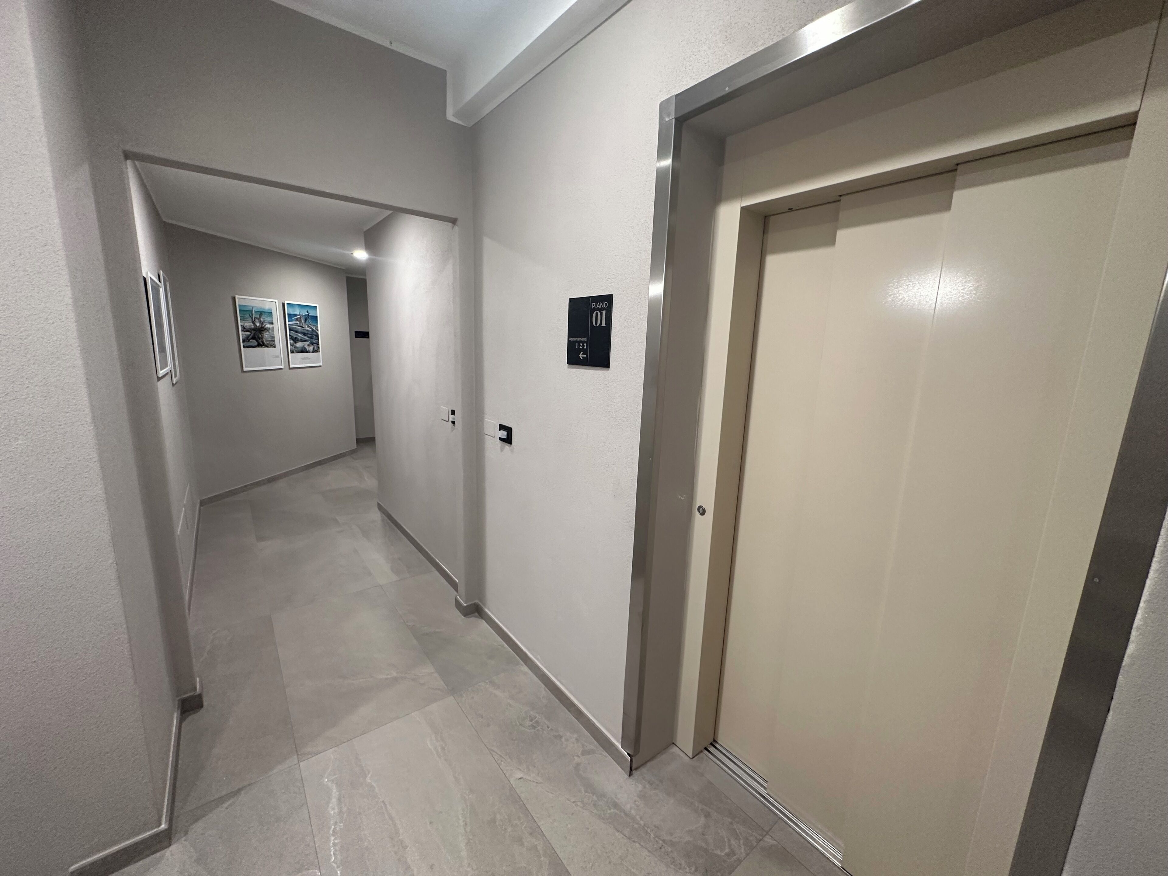 A hallway with a door labeled "Piano 01" and a sign indicating the direction to the piano.