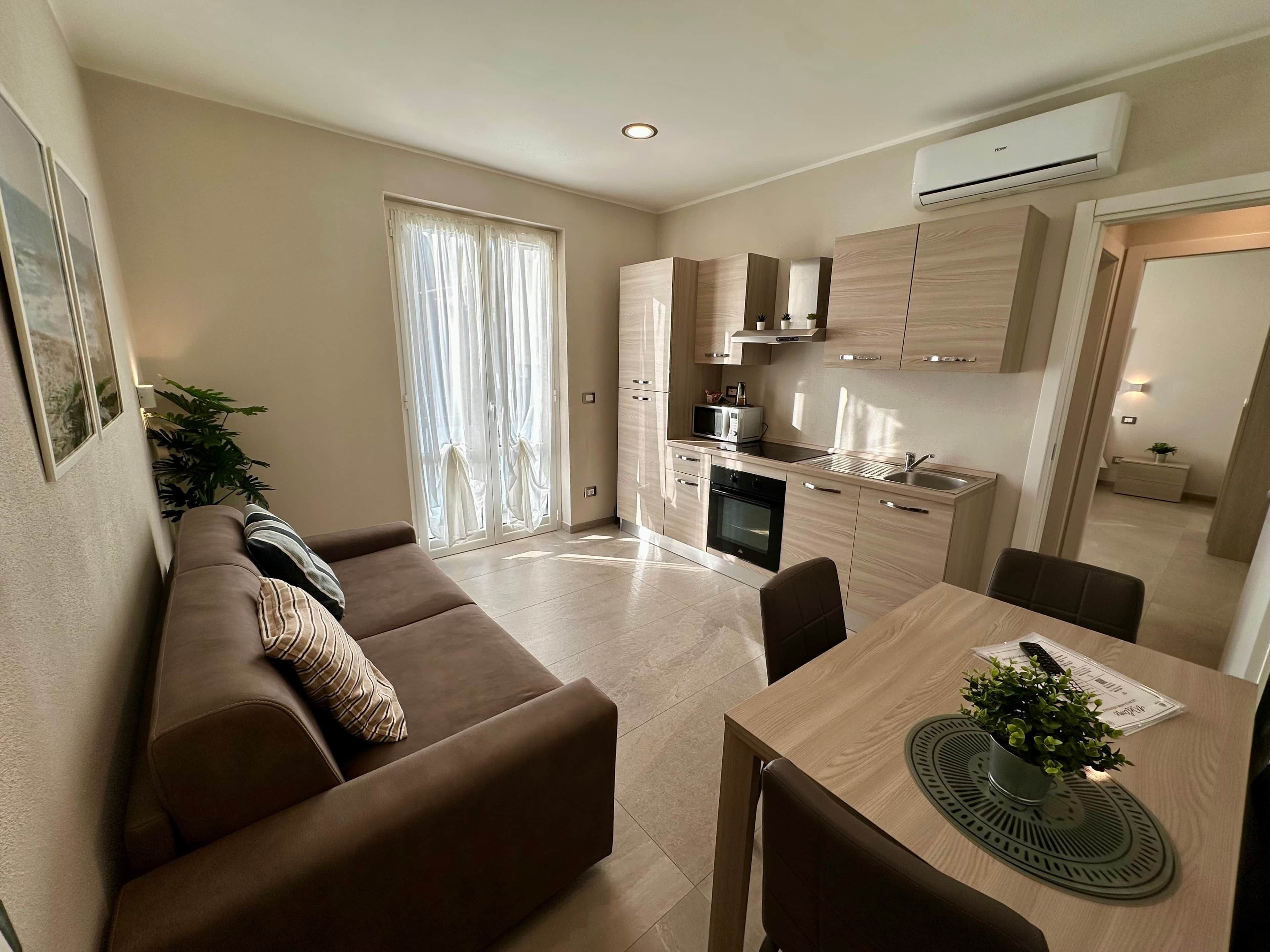Un appartement moderne comprenant un espace de vie, une kitchenette et un coin repas.