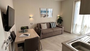 A compact living space with a kitchenette, a dining area, and a sofa. - Apartment N.3, Appartamento N.3 Primo piano (San Salvatore)