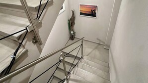 A staircase with a handrail and a picture on the wall.