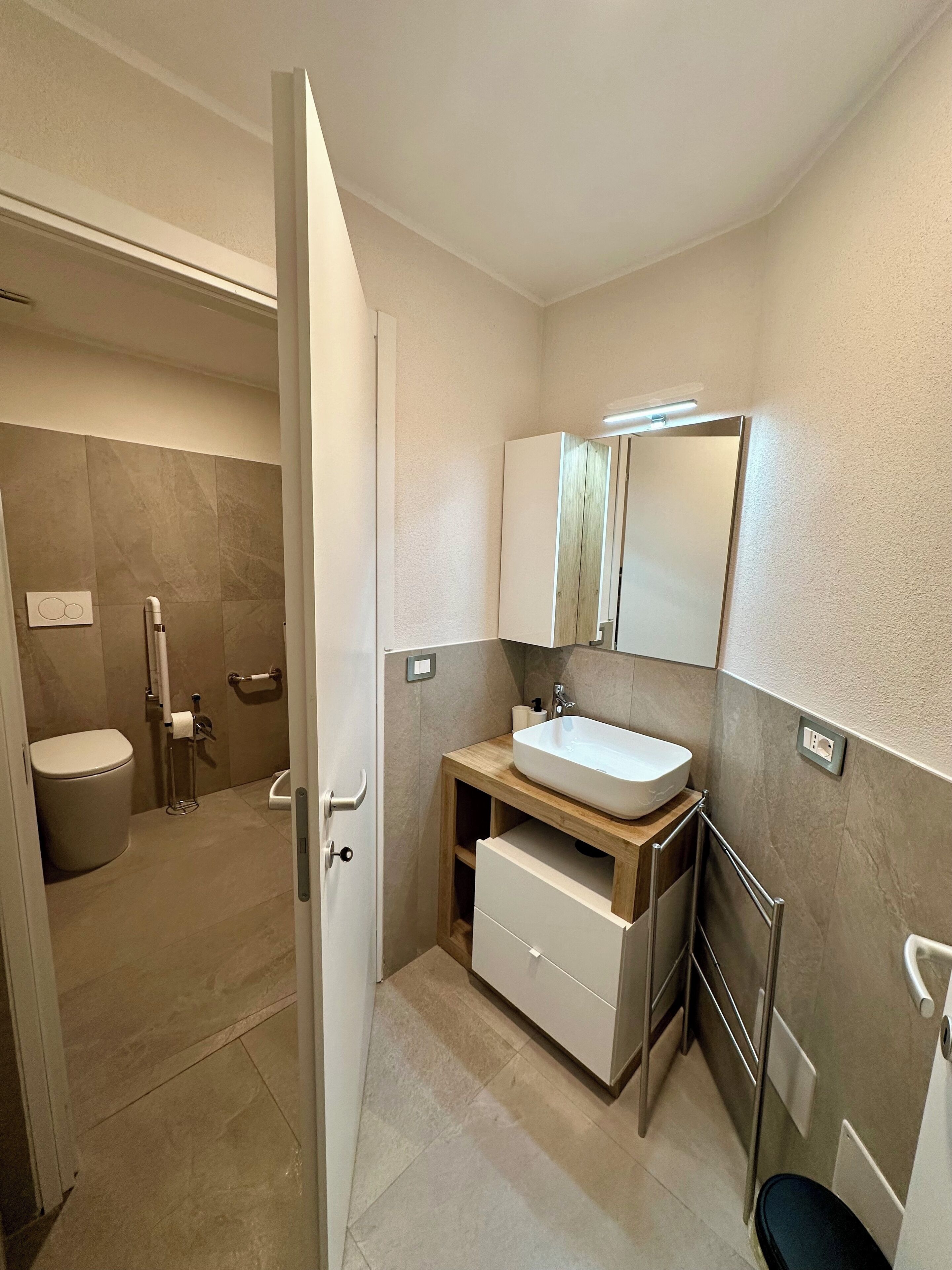 Une salle de bain moderne équipée de toilettes, d’un bidet et d’un lavabo avec un miroir au-dessus.