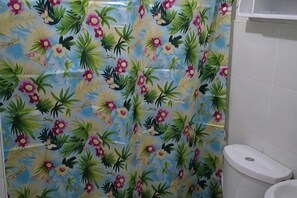 A bathroom with a floral tile pattern, a toilet, and a sink. - Kaseldorzhostel Transient at Moonwalk Paranaque (Paranaque)