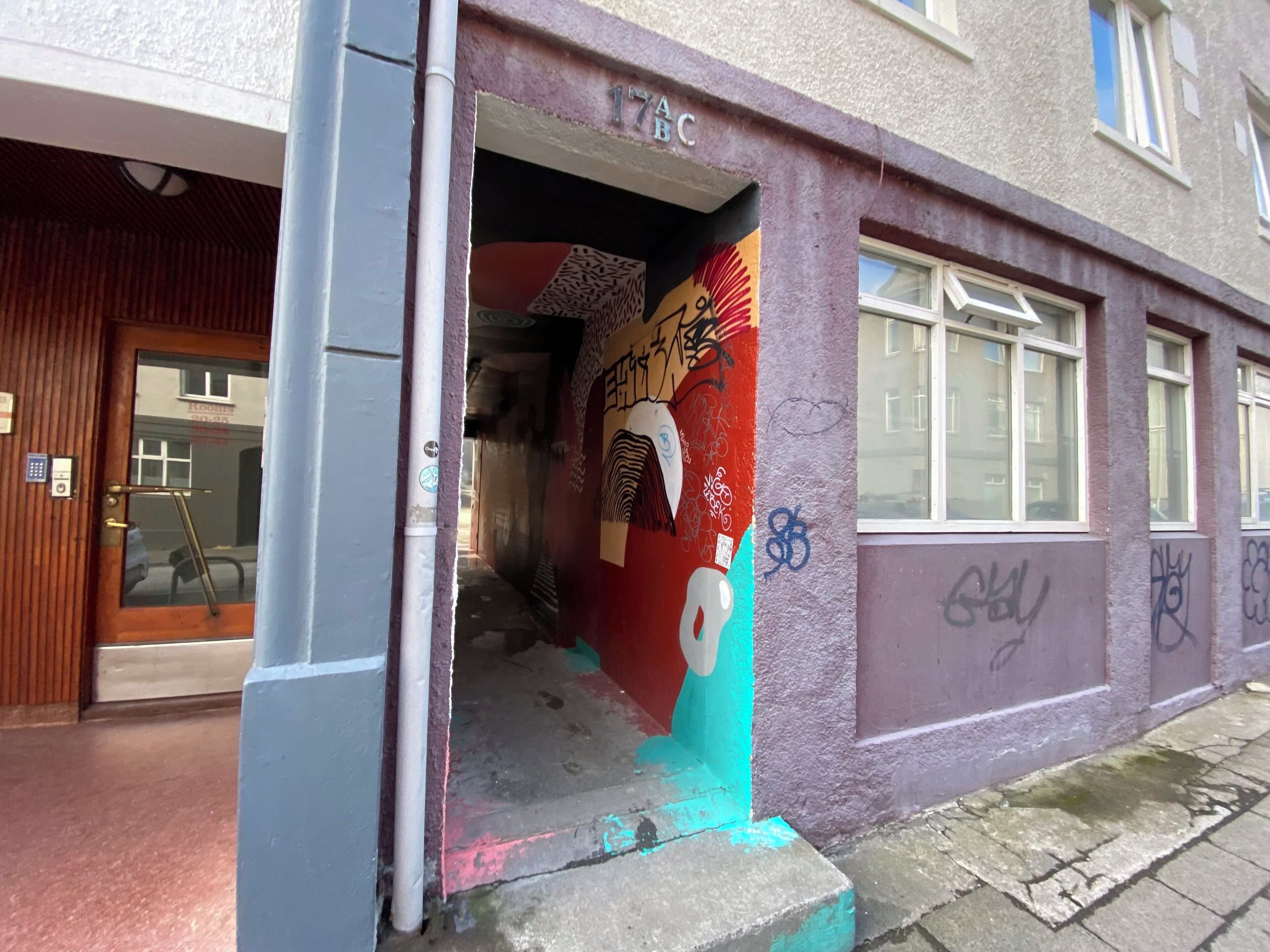 Ingresso di un edificio con una porta, una finestra e un muro con graffiti.