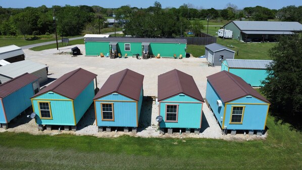 A row of small, single-story buildings with a simple, functional design, likely serving as cabins or cottages.