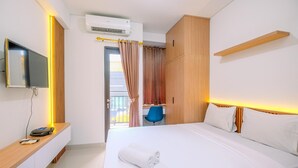 Une chambre d’hôtel équipée d’un lit, d’un bureau, d’une chaise, d’une télévision et d’un appareil de climatisation.