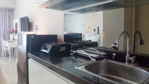 A modern kitchen with a stainless steel sink, a built-in stove, and a ventilation hood.