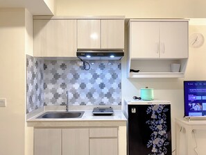Appartamento Deluxe | Cucina privata | Frigorifero, piano cottura, risottiera, tavolo da pranzo