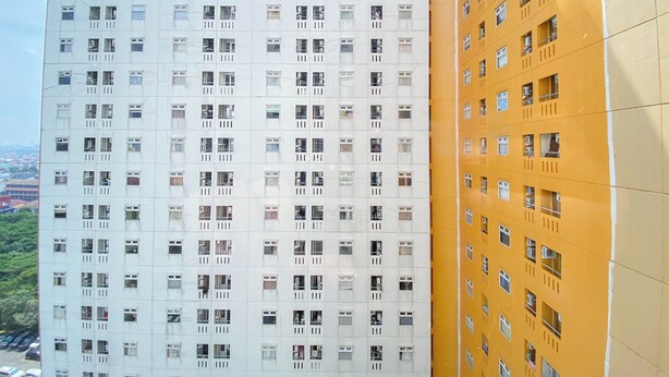 A high-rise building with multiple floors, each featuring numerous windows and balconies.