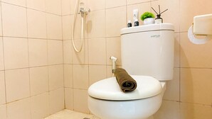 Ein modernes Badezimmer mit Toilette, Dusche und Toilettenpapierhalter.