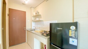 Eine kleine Küche mit Kühlschrank, Spüle und einer Arbeitsplatte.
