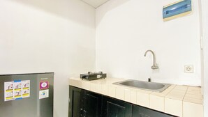 A small kitchenette with a refrigerator, a sink, and a microwave.