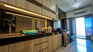 A modern kitchen with a large island, built-in appliances, and a view to the outside.