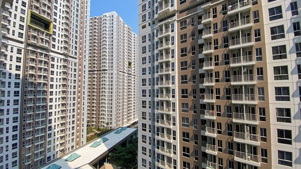 Un immeuble résidentiel de grande hauteur doté de nombreux balcons, d’une promenade centrale réservée aux piétons et d’une architecture moderne.