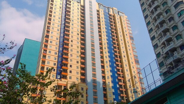 A high-rise building with multiple balconies and a modern architectural design.