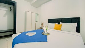 A hotel room with a bed, a wardrobe, and a mirror.