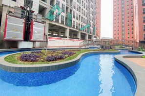 Relax by the pool surrounded by a mosaic-tiled edge and a bridge connecting the area.