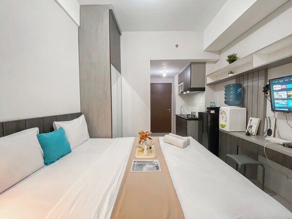 Relax in this stylish room with a made bed, kitchenette, and flat-screen TV.