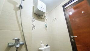 A bathroom with a shower, toilet, and a water heater. - Minimalist 2Br With Pool View At Gateway Pasteur Apartent (Cimahi)