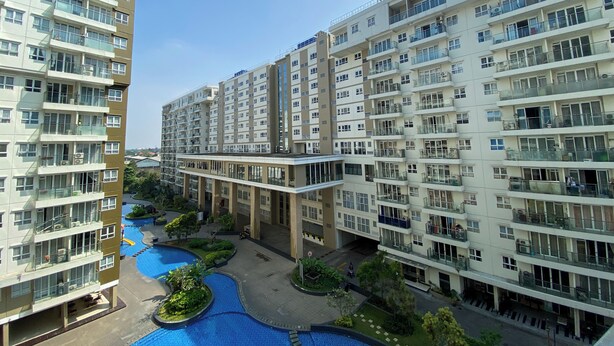 A multi-story residential building with balconies, a swimming pool, and a landscaped area. - Minimalist 2Br With Pool View At Gateway Pasteur Apartent (Cimahi)