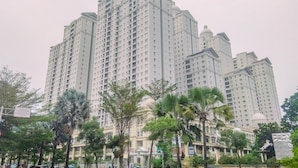 A high-rise residential building with multiple balconies and a dome-shaped top.