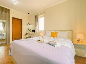 Relax in comfort with a large bed, bedside table, and chair, surrounded by ample storage and natural light.