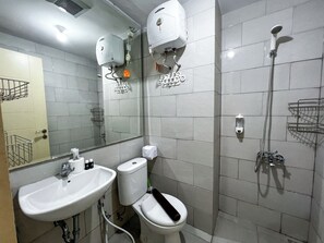 Un baño moderno con lavamanos, inodoro y ducha.