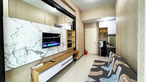 A modern living room with a marble wall-mounted TV, wooden furniture, and a patterned rug.