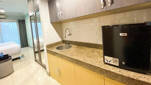 Een moderne keuken met granieten aanrechtbladen, een GEA-koelkast en een spoelbak.