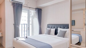 Une chambre d’hôtel avec un grand lit, un miroir, une fenêtre avec des rideaux et une vue sur l’extérieur.