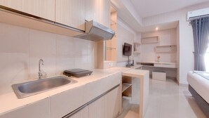 Une cuisine moderne équipée d’une cuisinière intégrée, d’un évier et d’un téléviseur à écran plat fixé au-dessus du plan de travail.