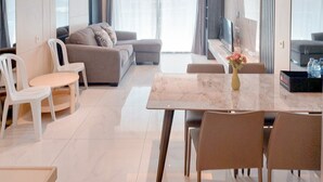 A modern living room with a marble coffee table, a sofa, and a TV. - Best Place And Wonderful 3Br Apartment Sky House Bsd Near Aeon Mall (Pagedangan)